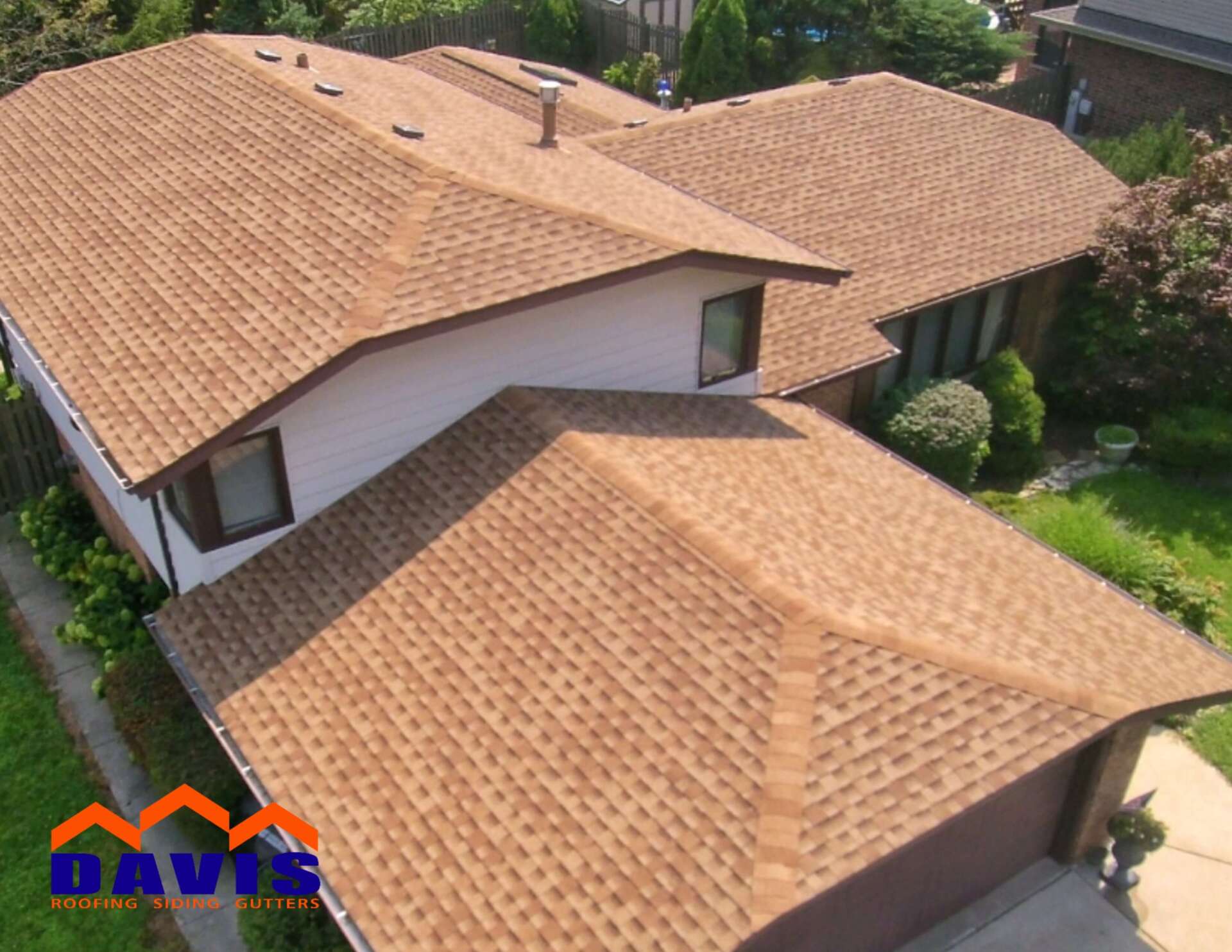 Brown shingled roof on a two-story house, seen from above; the logo 