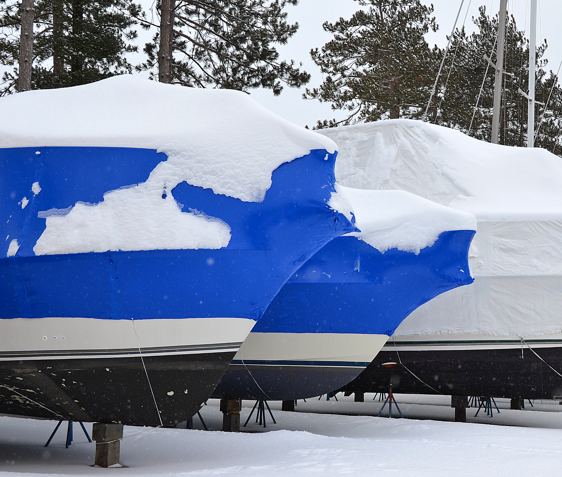 A blue and white boat is covered in snow