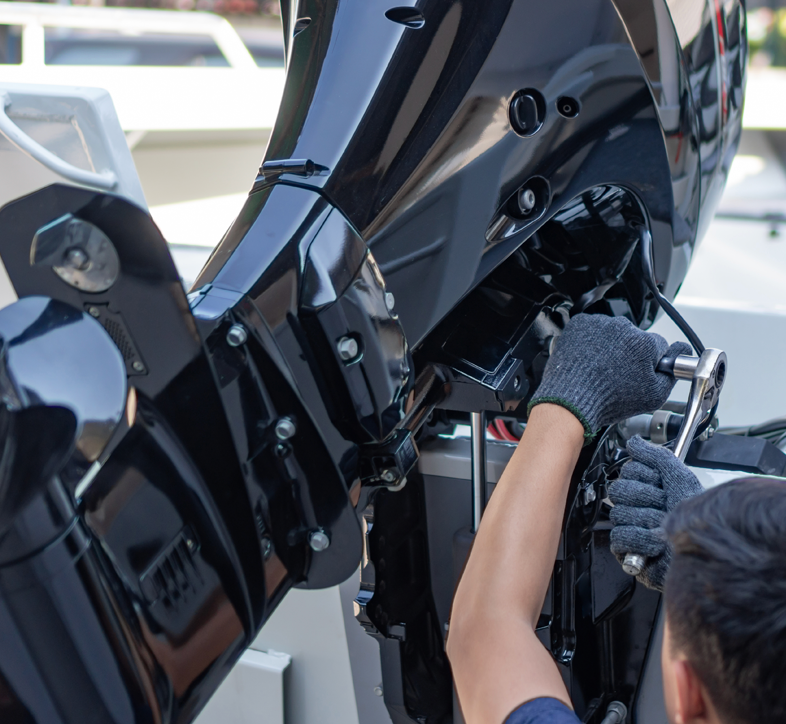 A young boy in a life jacket is looking out over a lake.
