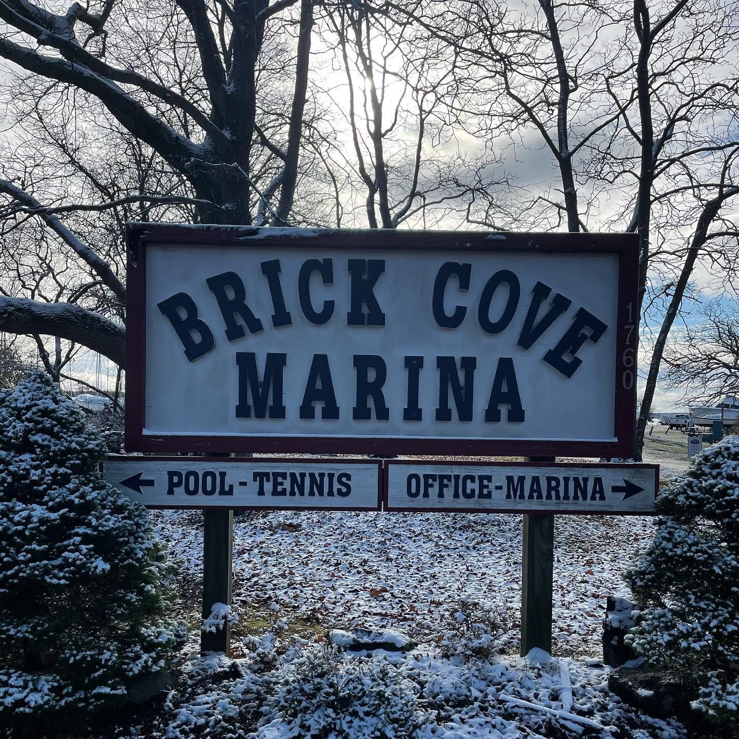 Sign for Brick Cove Marina in winter; shows directions to pool-tennis and office-marina.