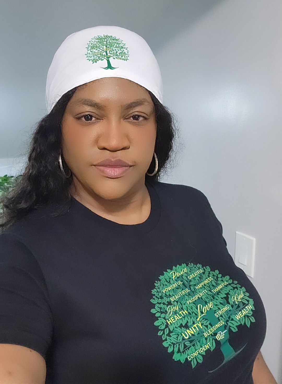 A woman wearing a white hat and a black shirt with a tree on it