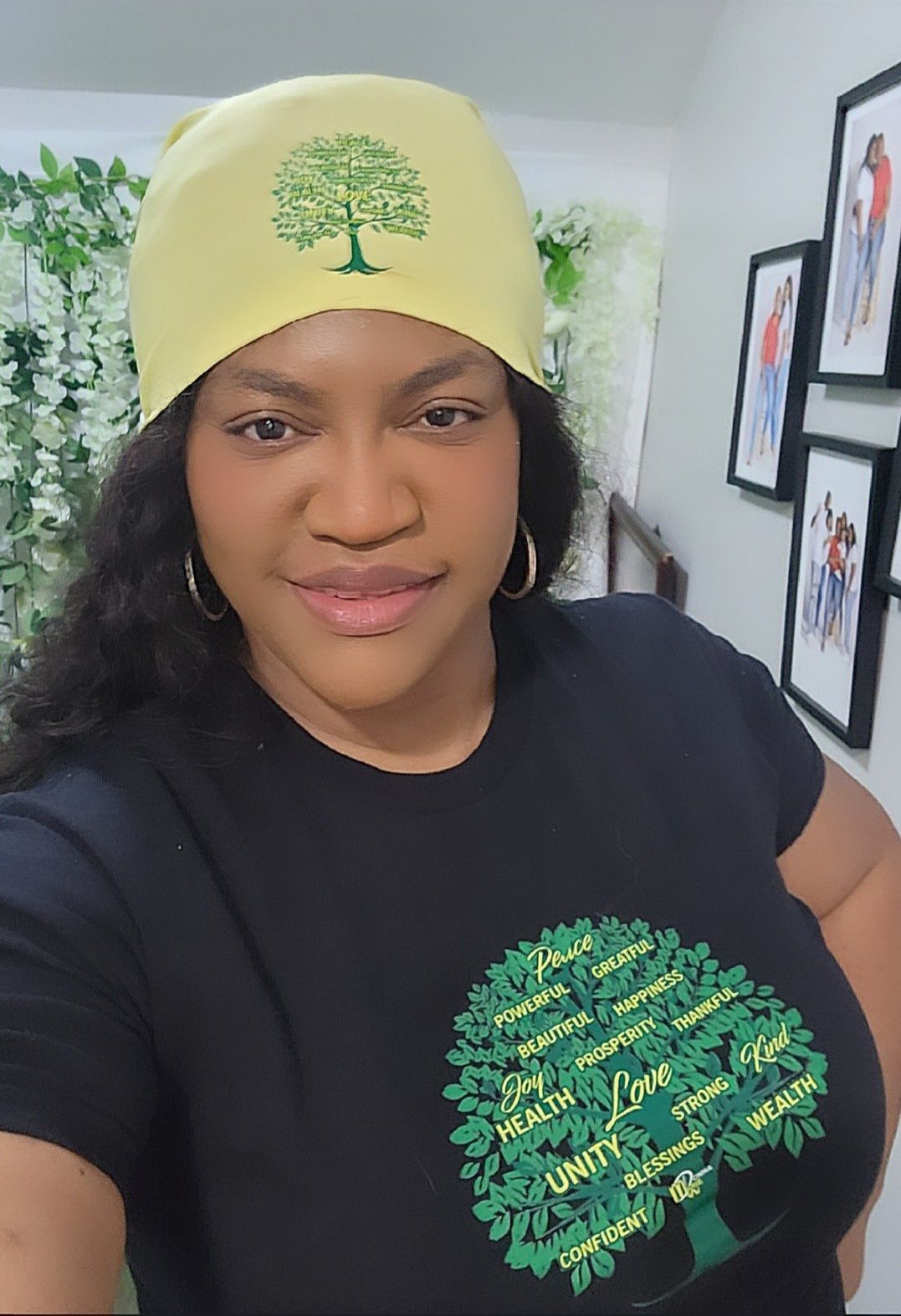 A woman wearing a yellow beanie and a black shirt with a tree on it