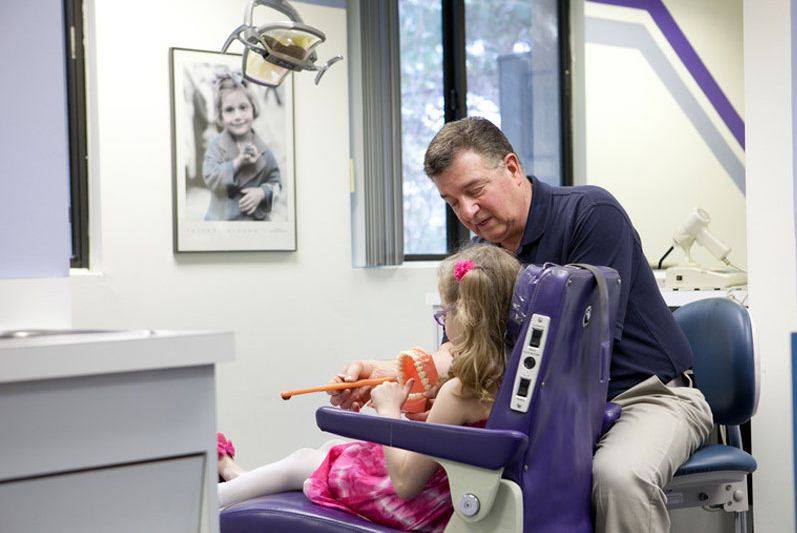 Dr. steven talking to a kid on a dental chair — kids dentist in Manalapan, NJ