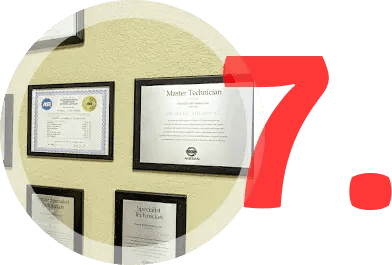 Certificates framed on a wall, partially obscured by a large red number