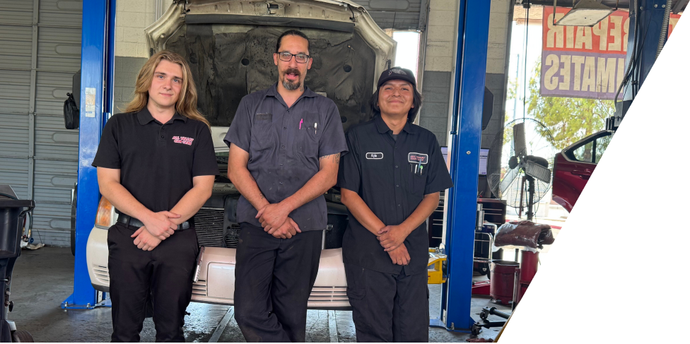 Mechanic with a tablet checking an Audi engine with the hood open in a garage. | All Valley Car Care