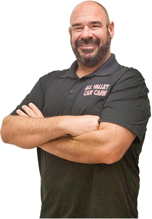 Man with crossed arms wearing a black shirt that says 