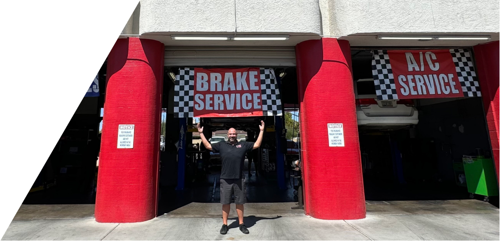 Mechanic with a tablet checking an Audi engine with the hood open in a garage. | All Valley Car Care