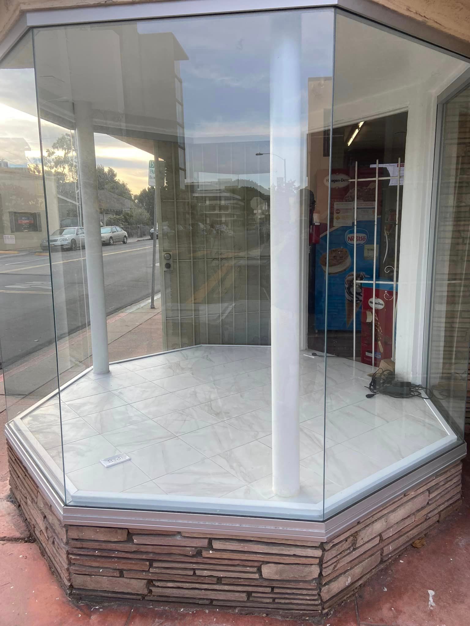 An empty store front with a glass window and a stone wall.