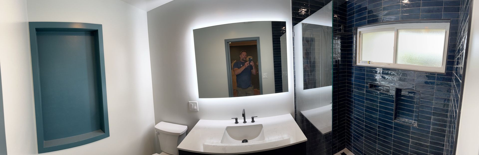 A bathroom with a sink , mirror and toilet.