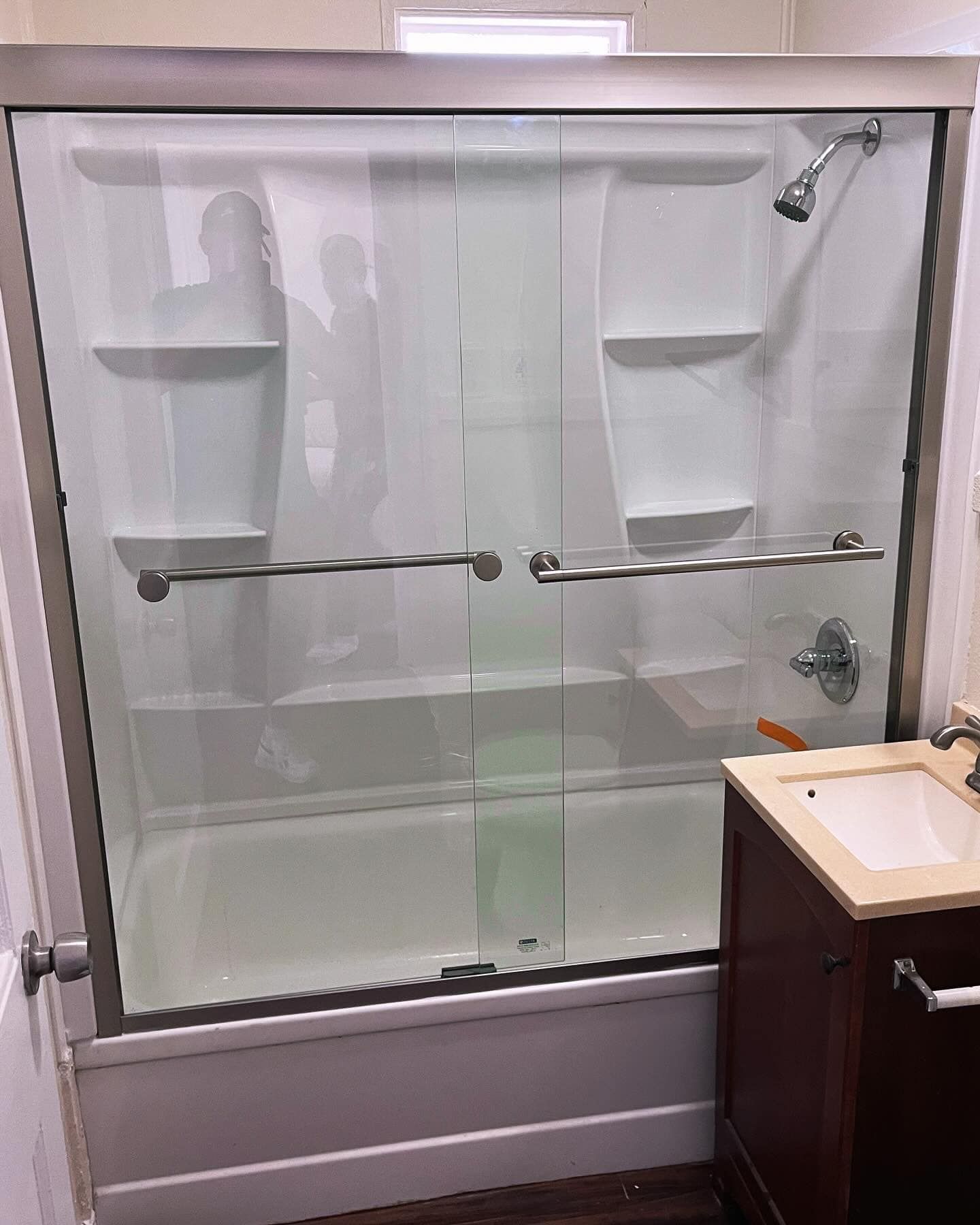 A bathroom with a sliding glass shower door and a bathtub.
