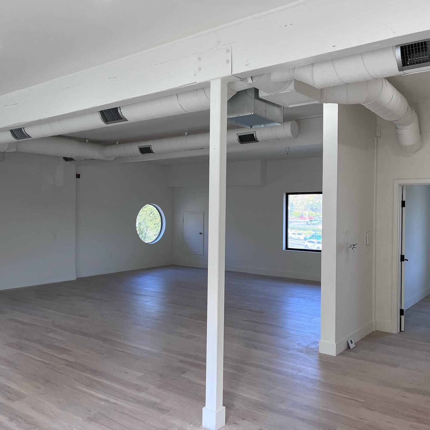 A large empty room with hardwood floors and white walls