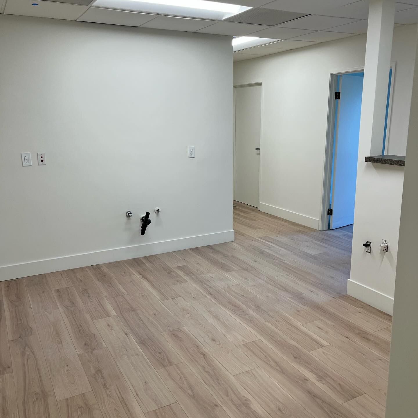 An empty room with hardwood floors and white walls.