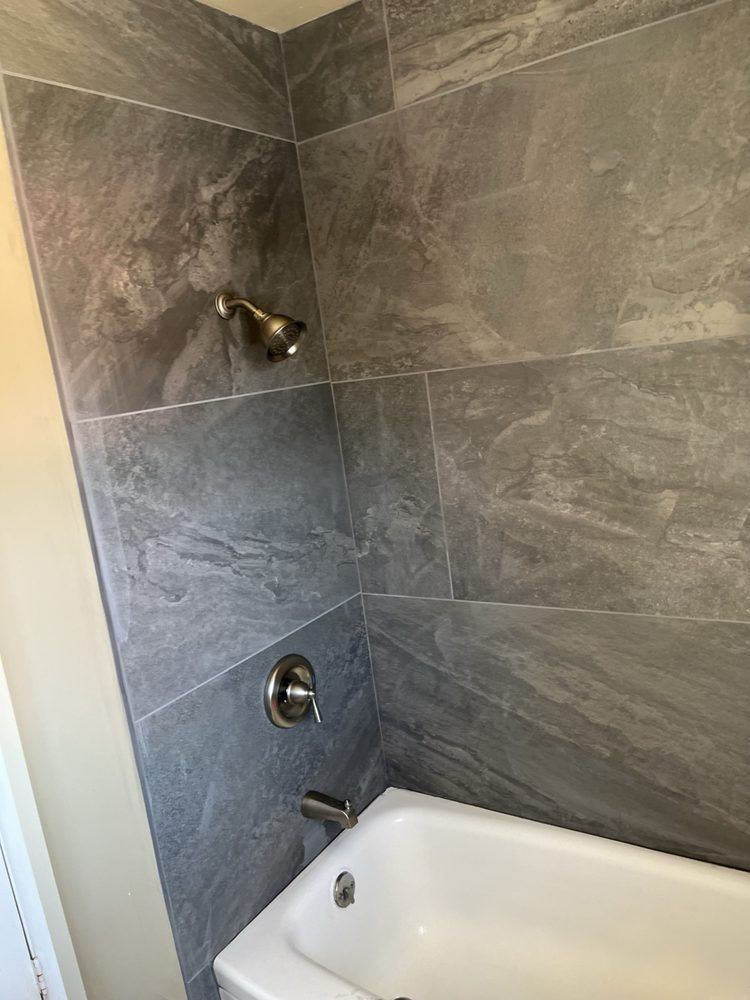 A bathroom with a bathtub and a shower head.