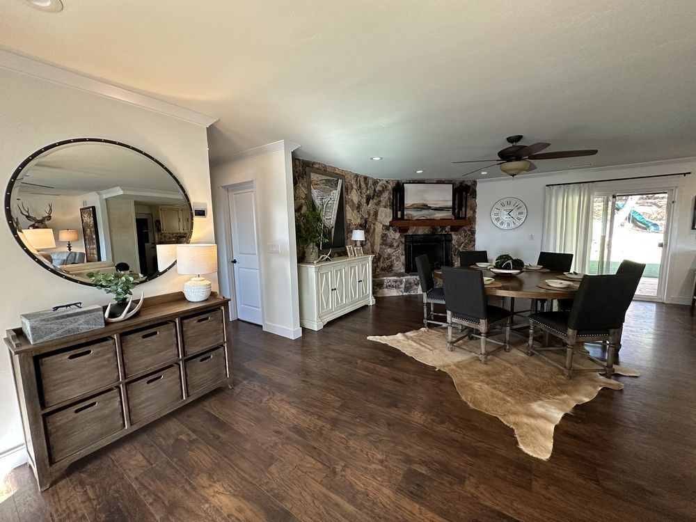 A living room with a dining table , chairs , and a mirror.