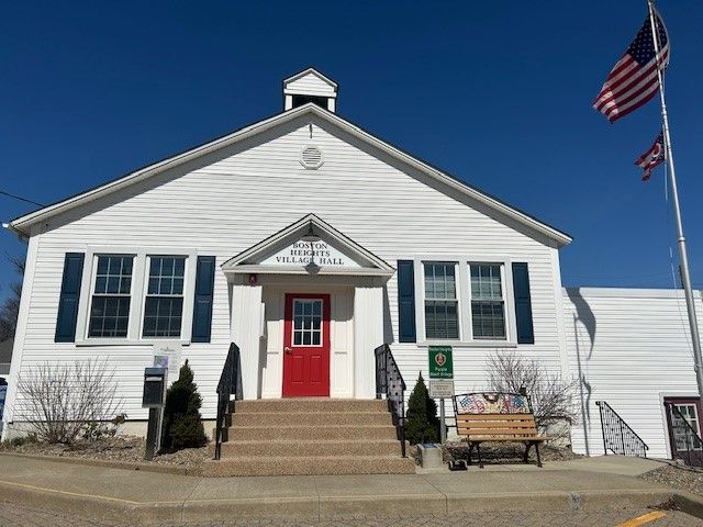 Village Hall with a red door and an american flag in front of it