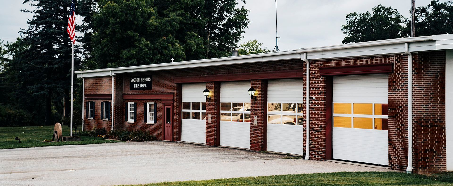 A row of garage doors are lined up in front of a brick building.