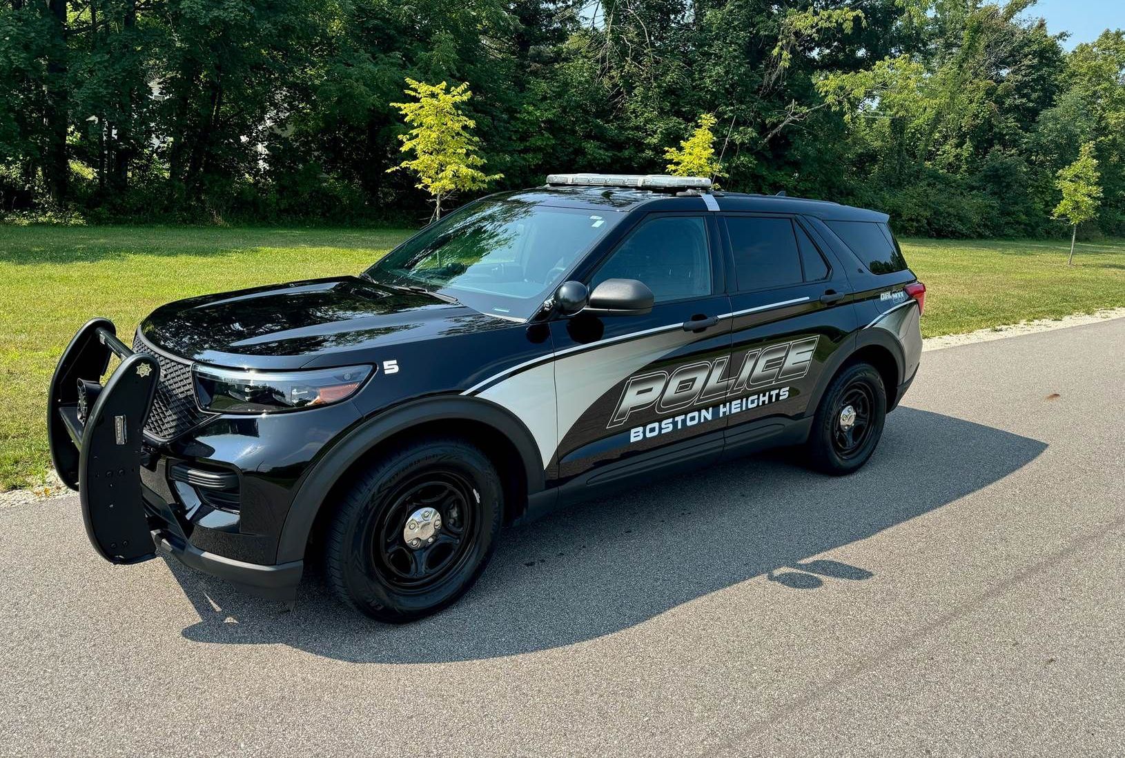 A black and white police car is parked on the side of the road.
