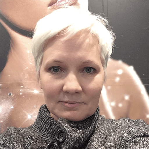 55 year old woman with no makeup in front of sparkly background