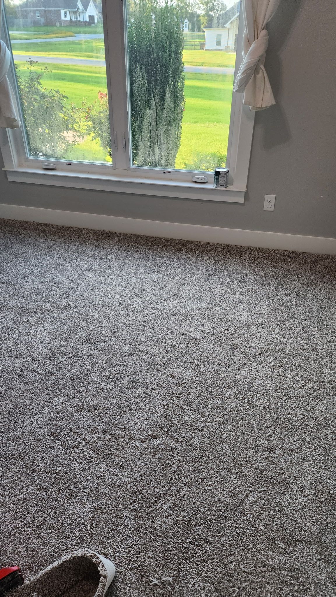 Room with gray carpet, window, and gray walls.