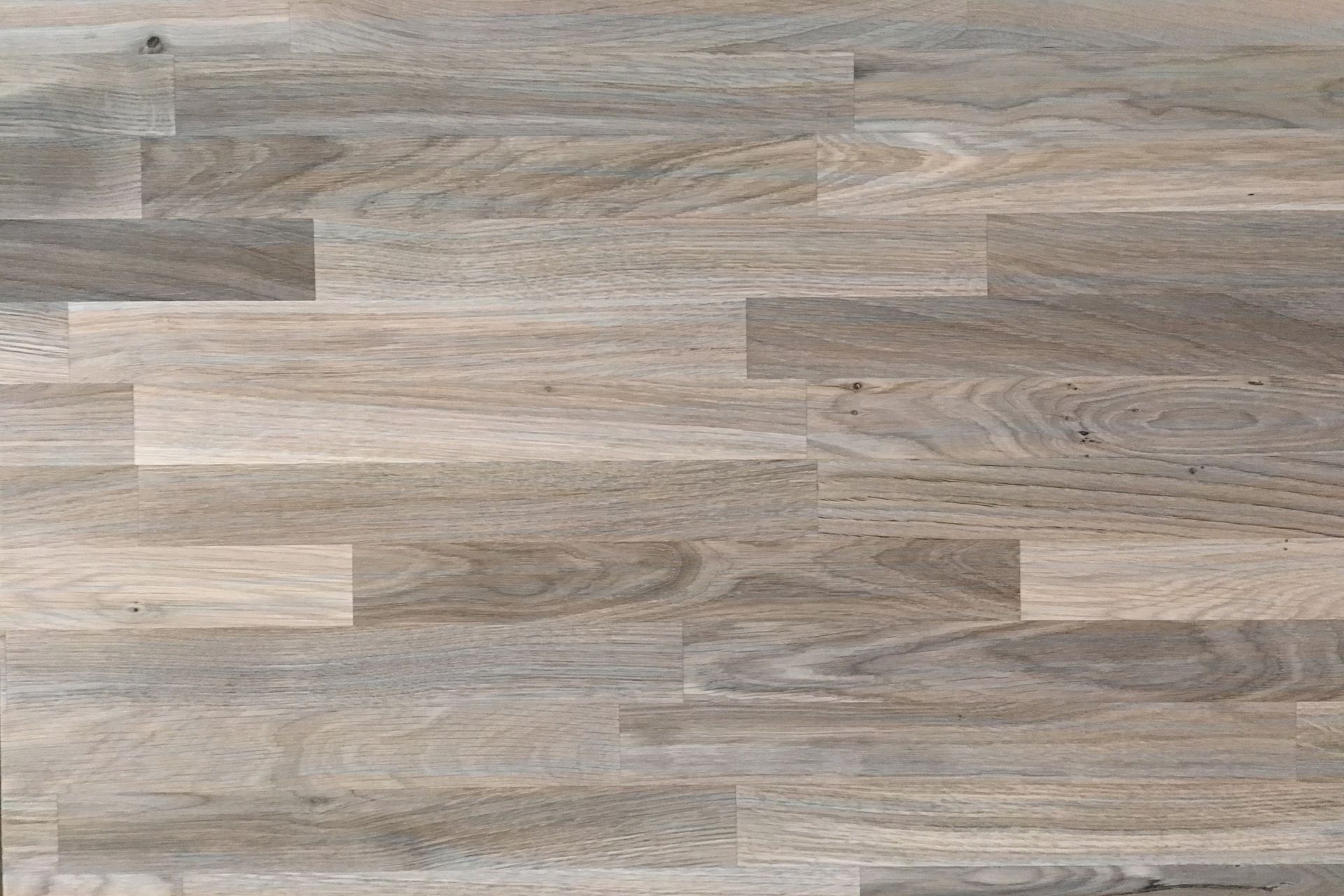 Wood floor, light brown and gray with a geometric pattern.
