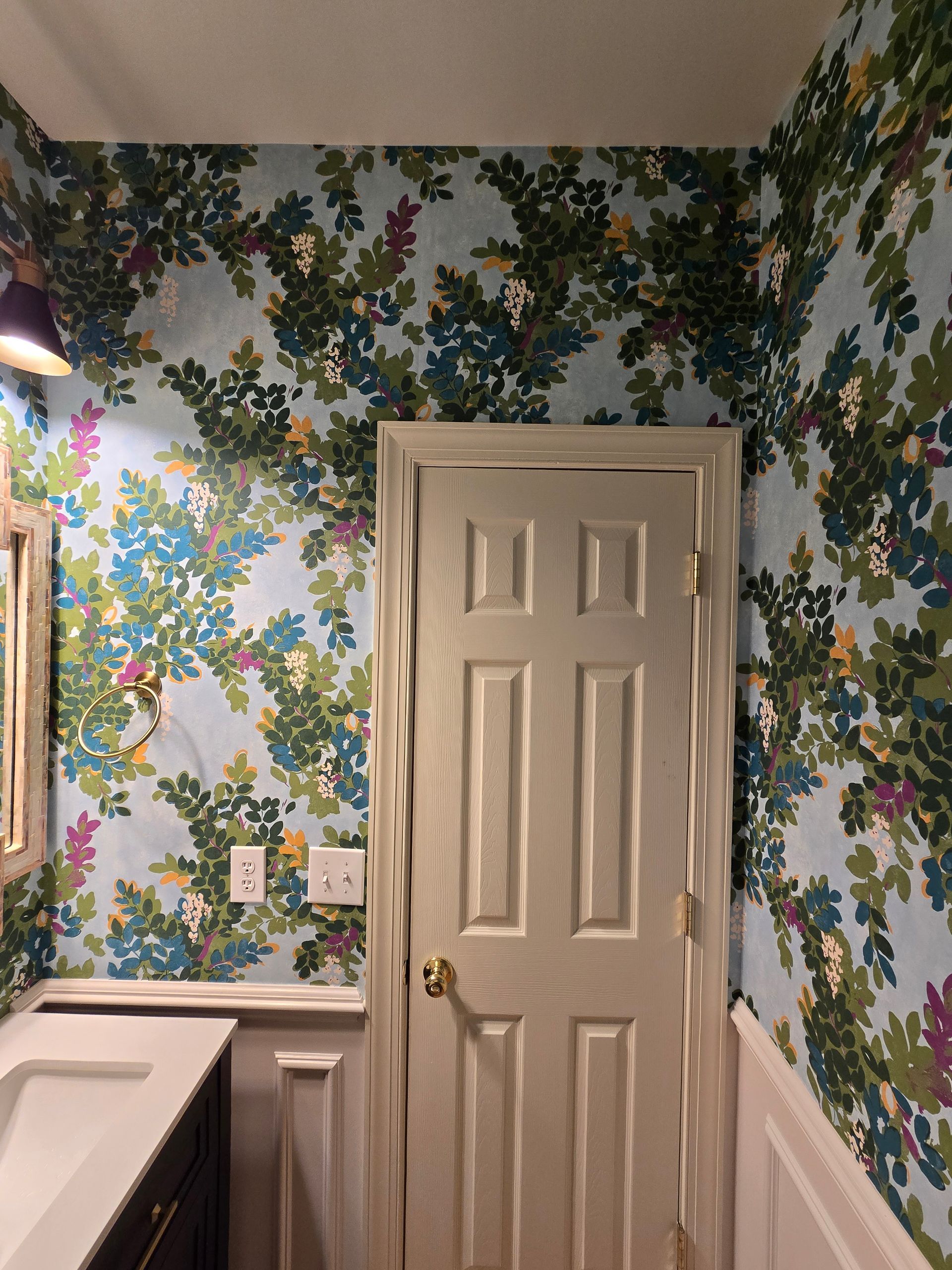 A bathroom with flowers on the wall and a sink