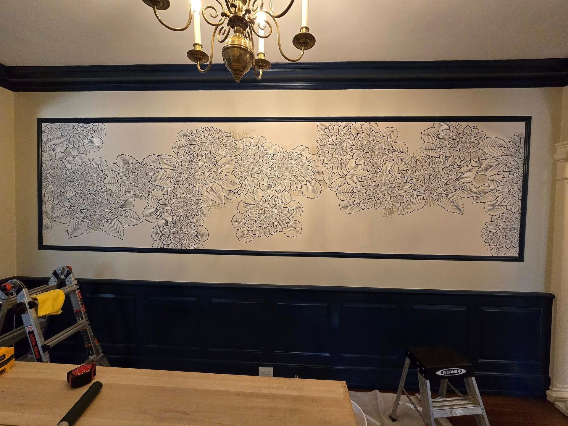 A large painting is hanging on a wall in a room.