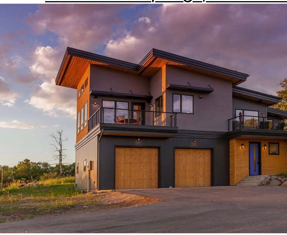 A large house with two garage doors and a balcony