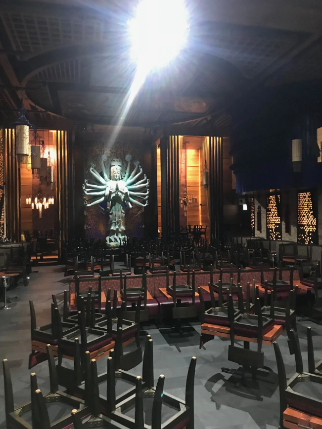 A room with a lot of chairs and a statue on the wall