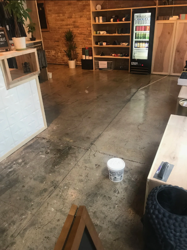 A dirty floor in a restaurant with a bucket on it