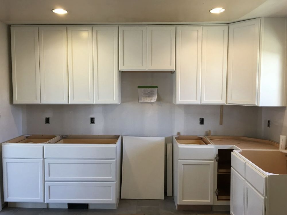 A kitchen with white cabinets and drawers is being remodeled.