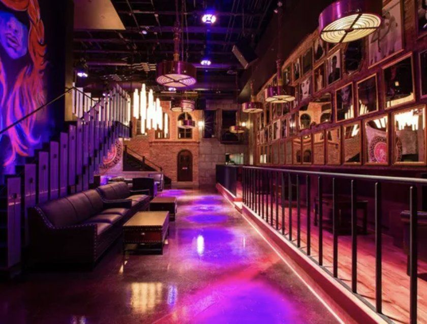 A large room with purple lights on the floor and stairs.