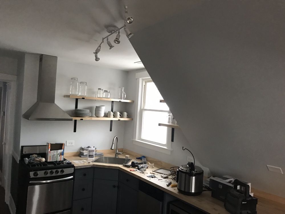 A kitchen with a stove a sink and a window