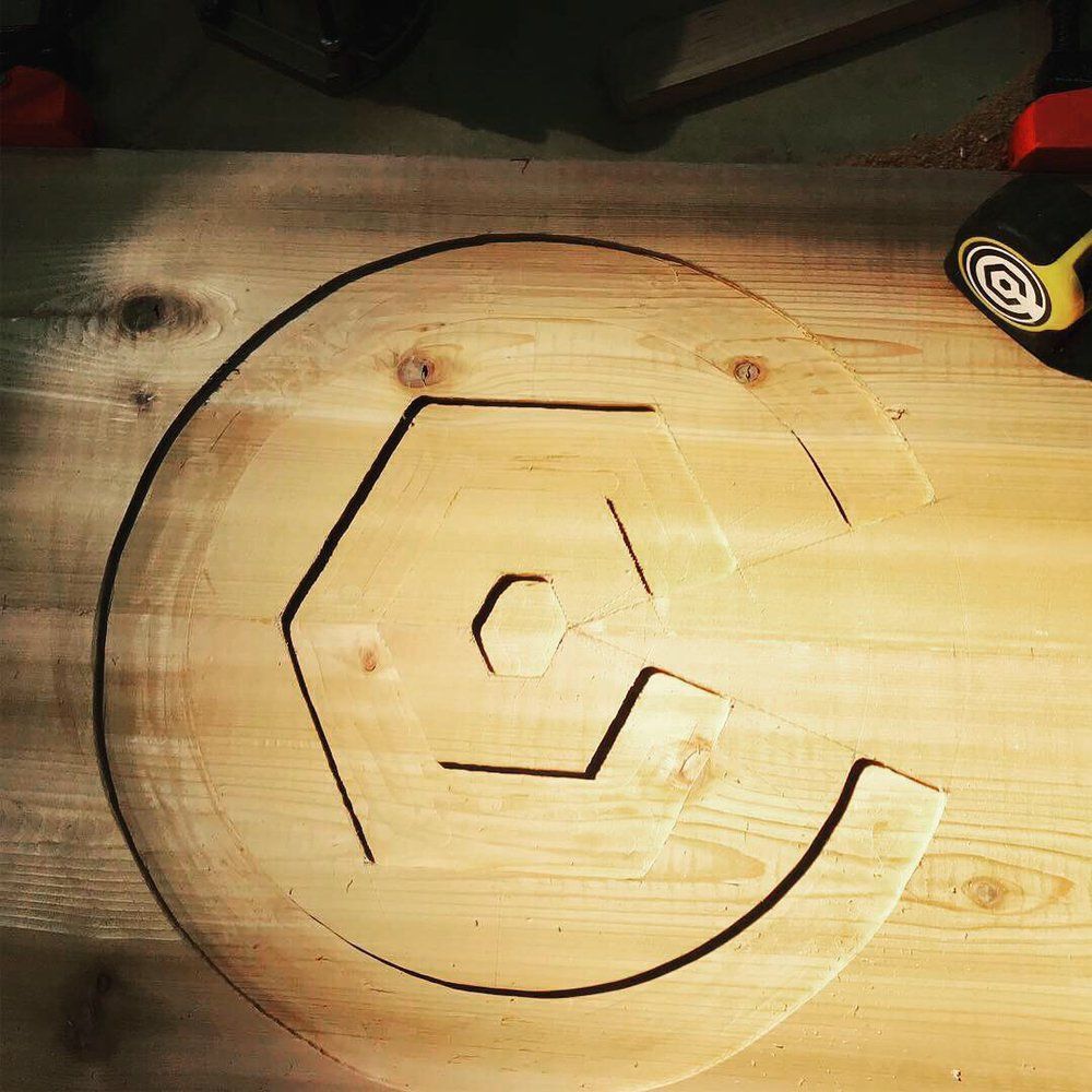 The letter g is carved into a piece of wood