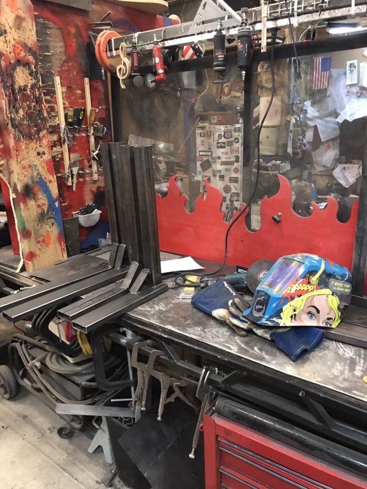 A welding helmet is sitting on a table in a workshop.