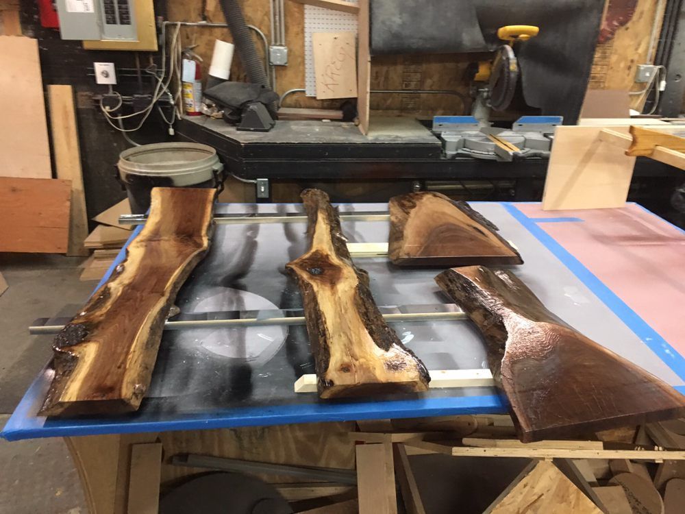 Three pieces of wood are sitting on a table in a workshop.