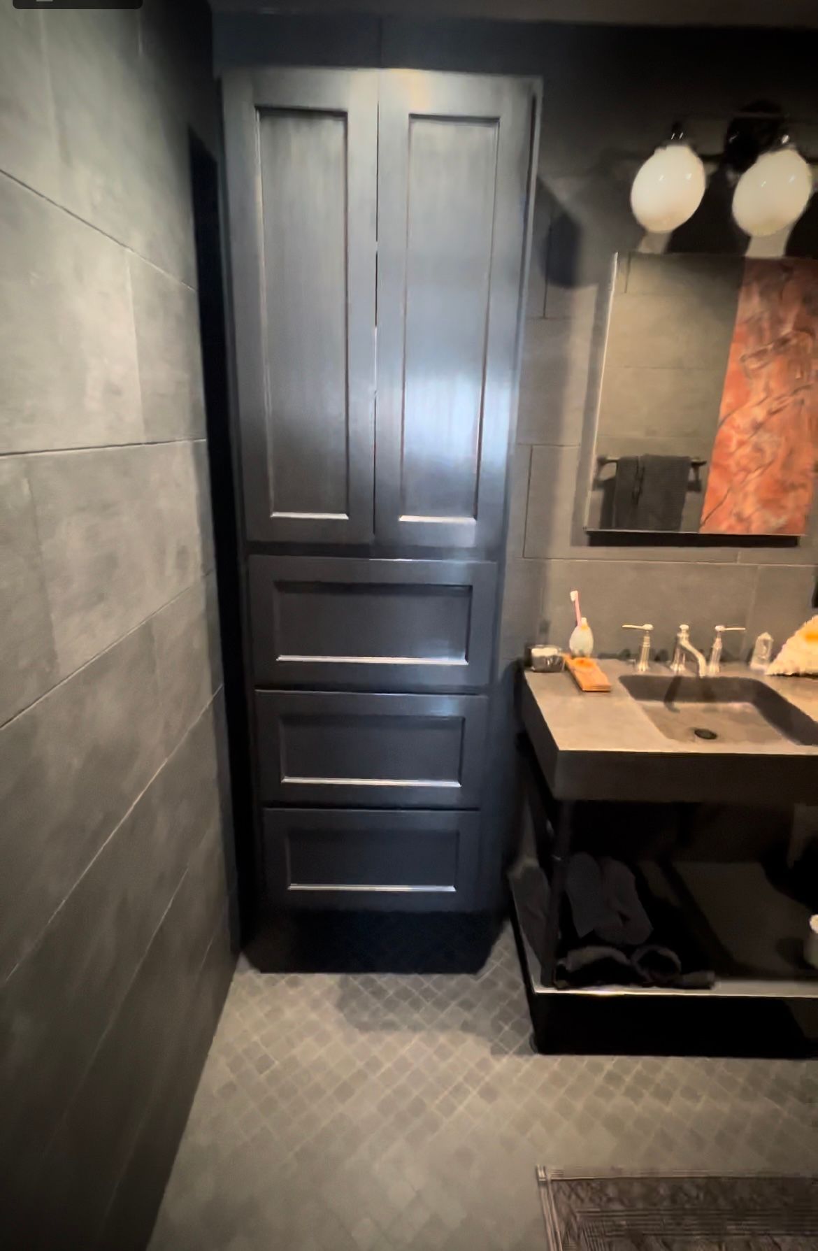 A bathroom with a sink , cabinets , and a mirror.