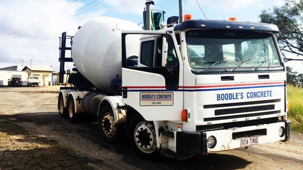 a boodles concrete truck is parked on a dirt road