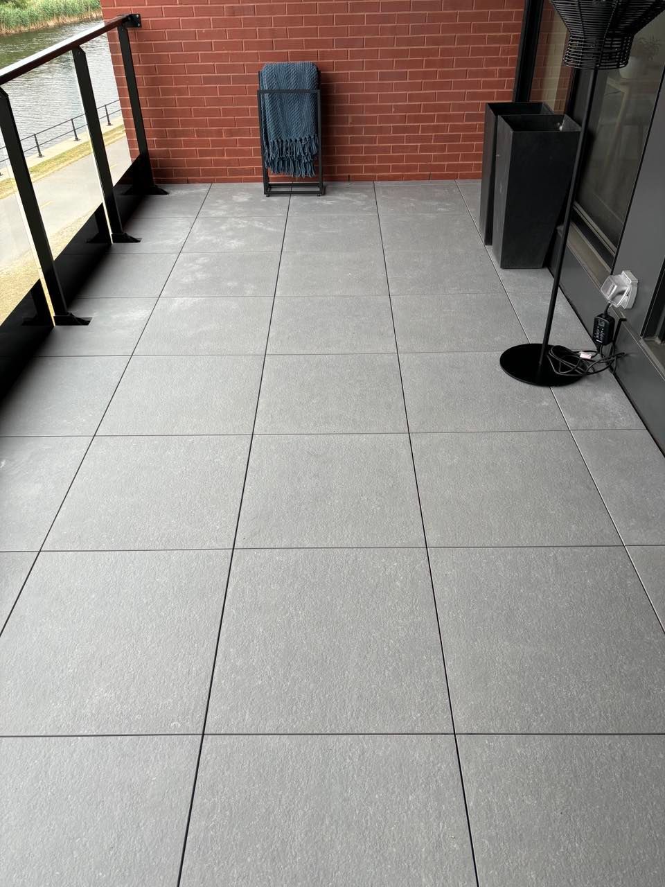 Un balcon avec une chaise et une lampe dessus.