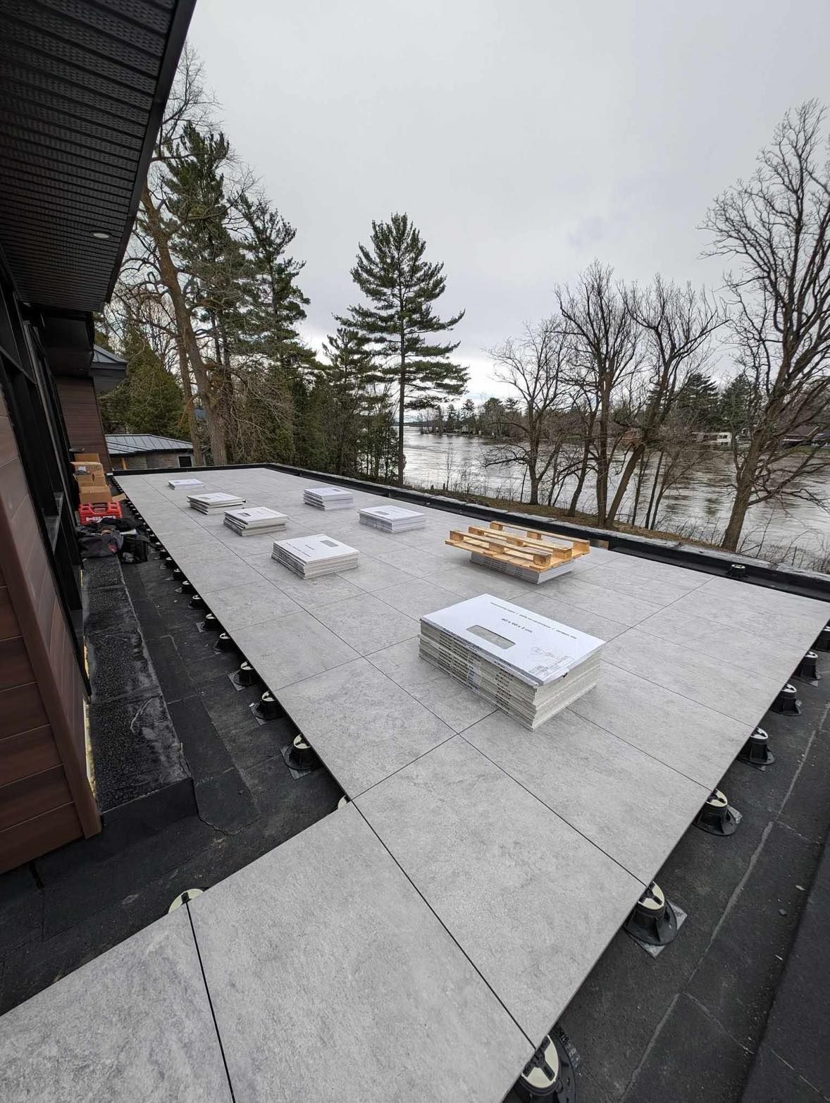 Un toit avec vue sur un lac et des arbres en arrière-plan.