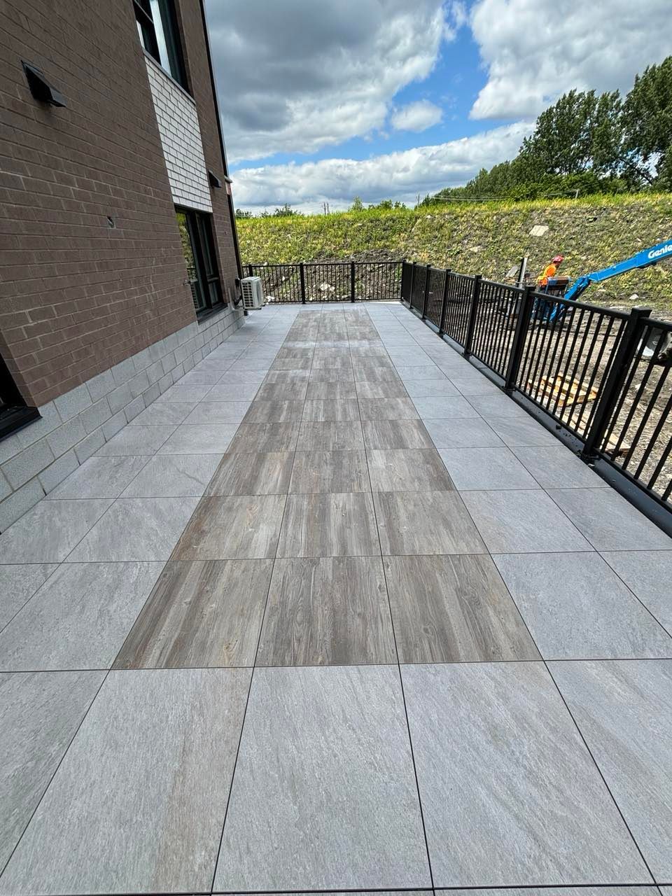 Un patio avec une clôture et un bâtiment en briques en arrière-plan.