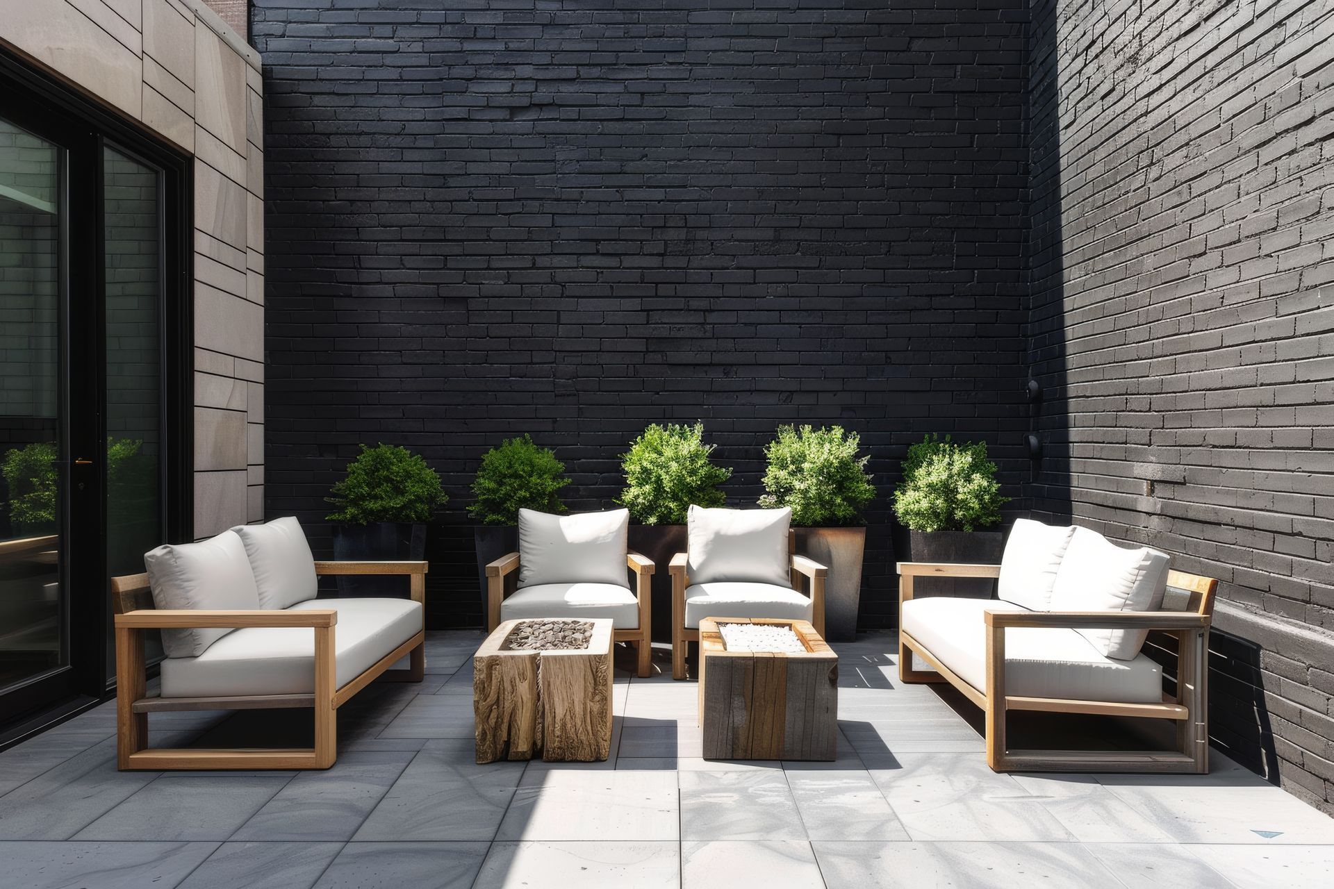 Un patio avec mobilier et un foyer devant un mur de briques noires.