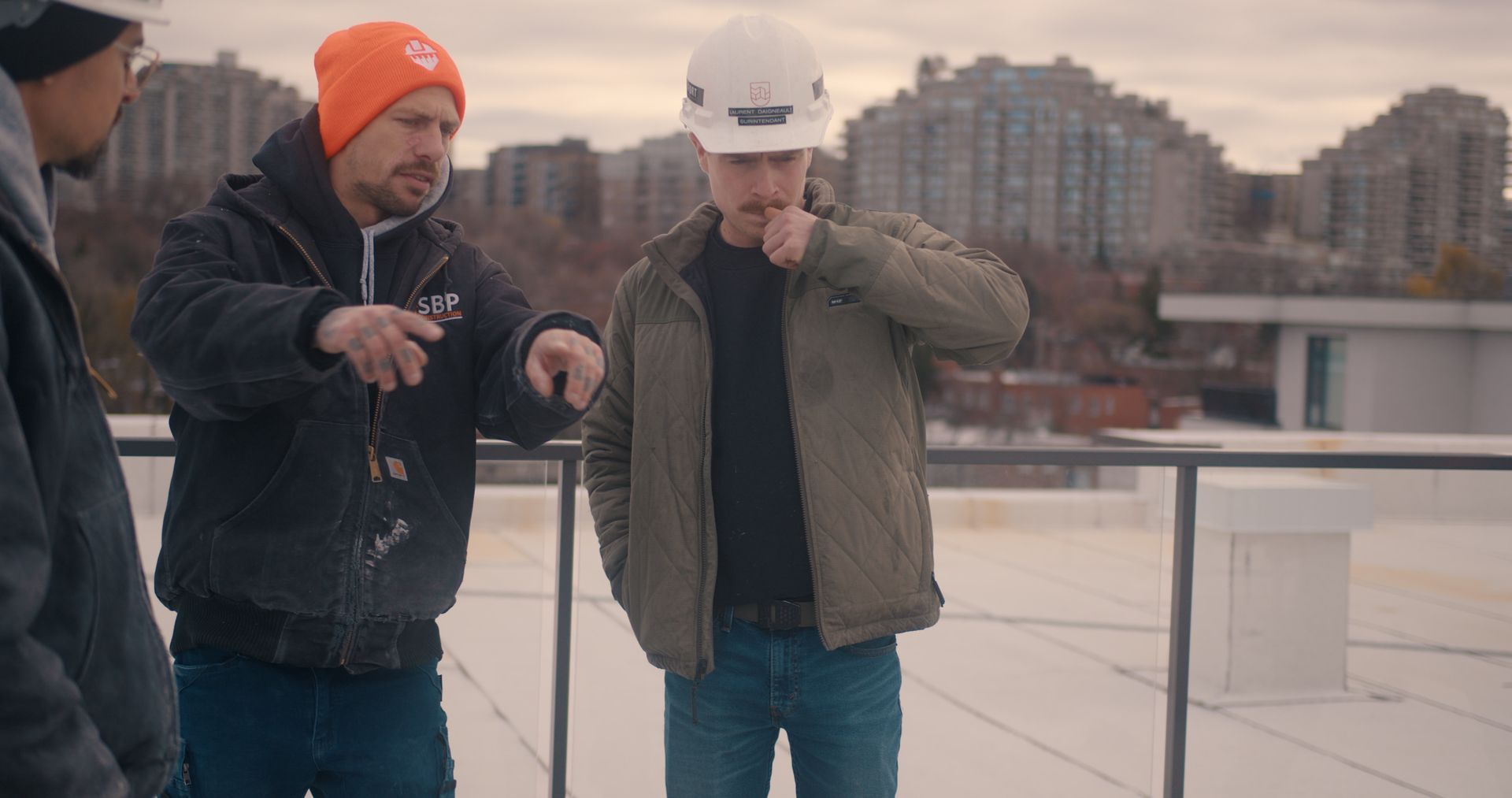 Un groupe d'ouvriers du bâtiment se tient au sommet d'un toit.