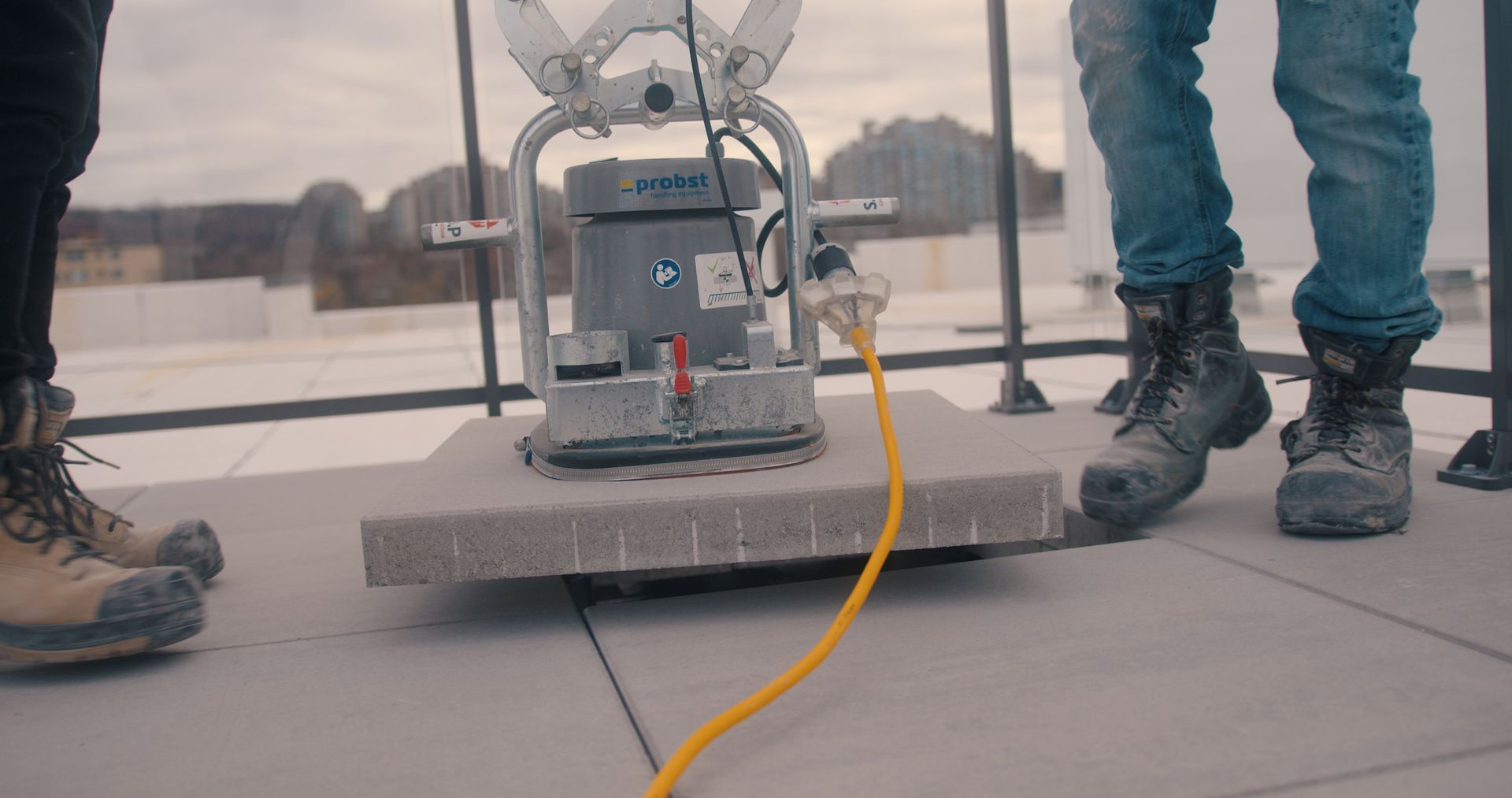 Une personne se tient à côté d'une machine sur un toit.