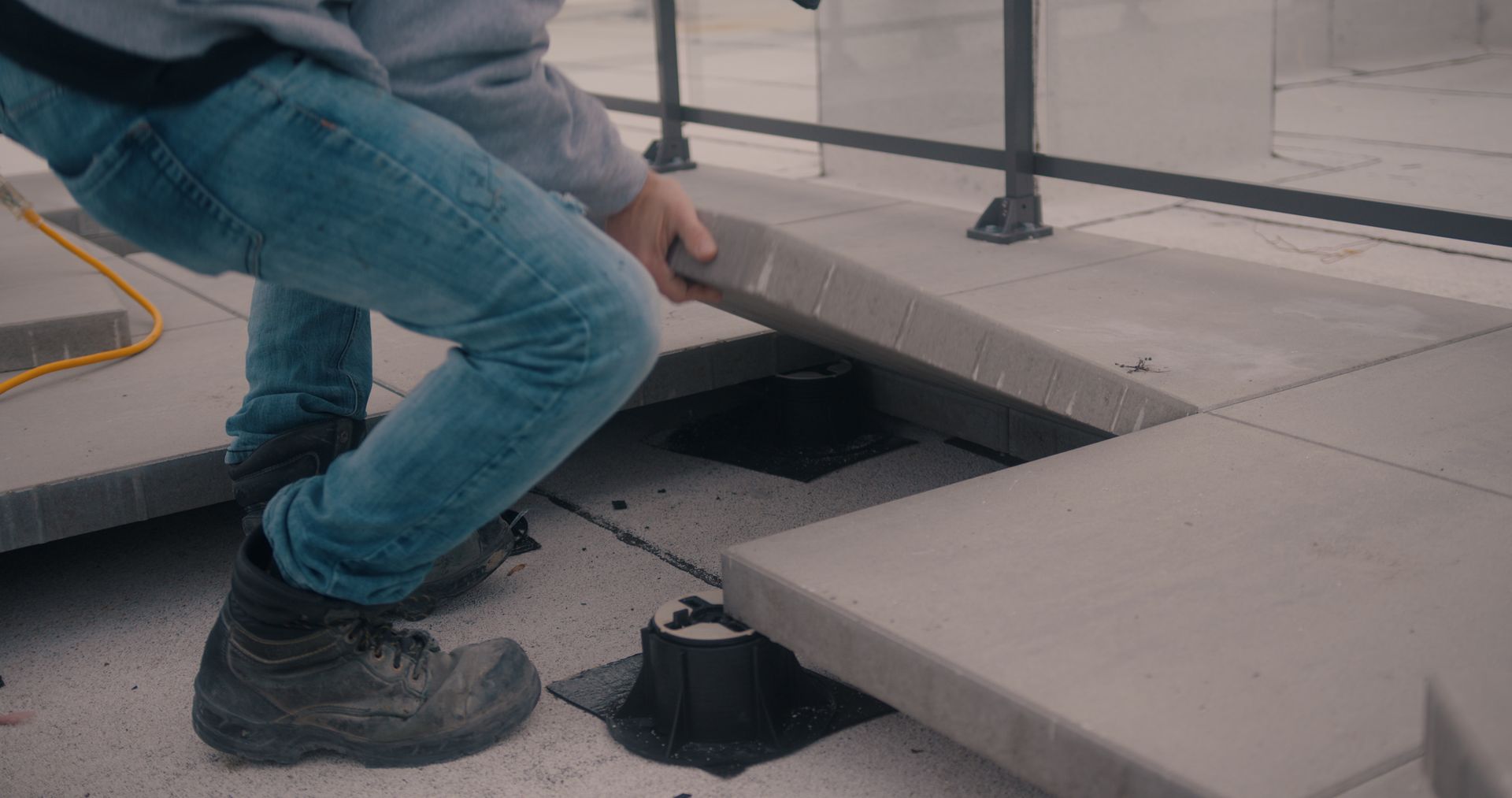 Une personne se tient debout sur un sol en béton.