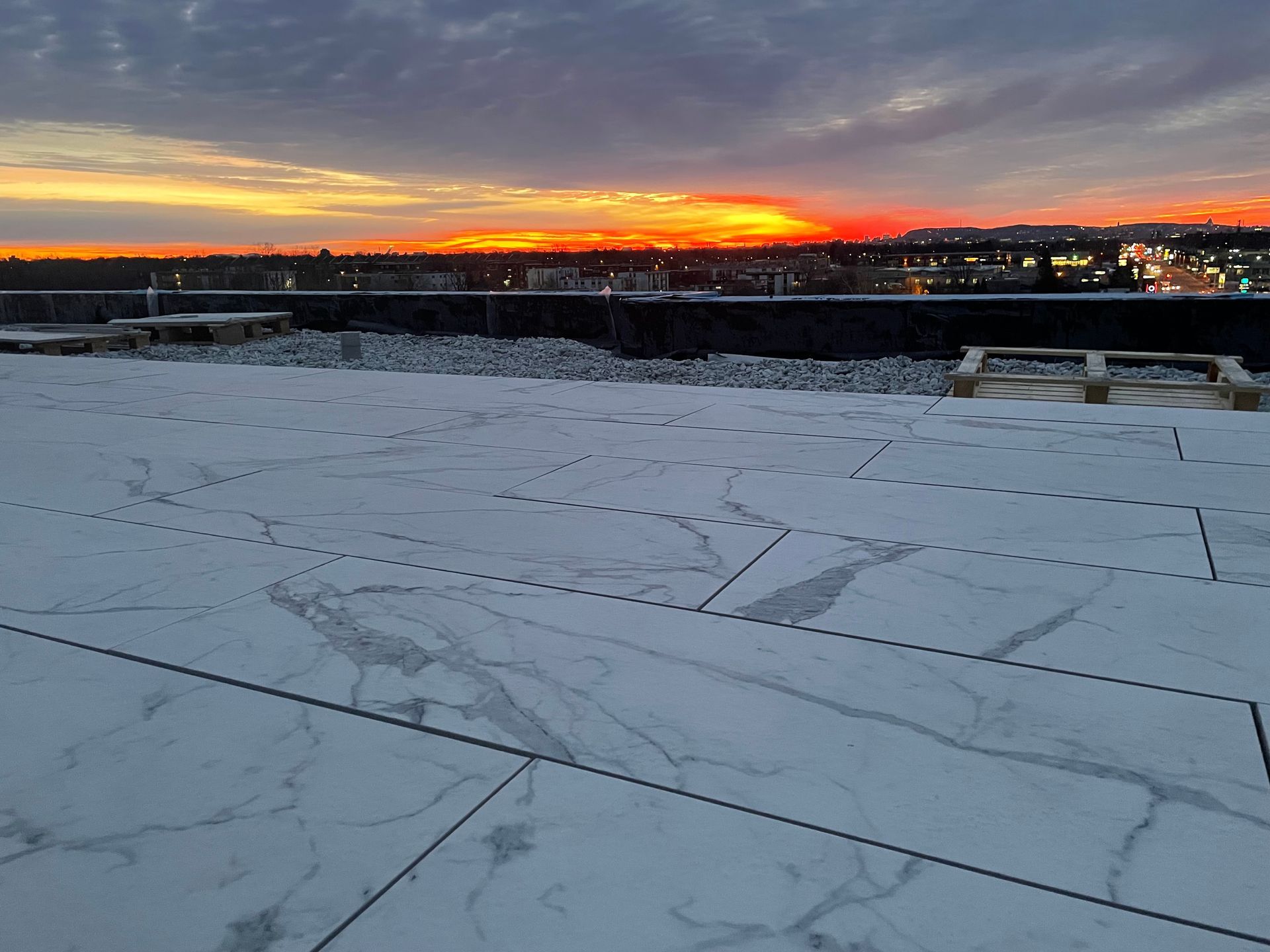 Des pavés à motif de marbre blanc ont été installés sur une terrasse sur le toit au coucher du soleil.