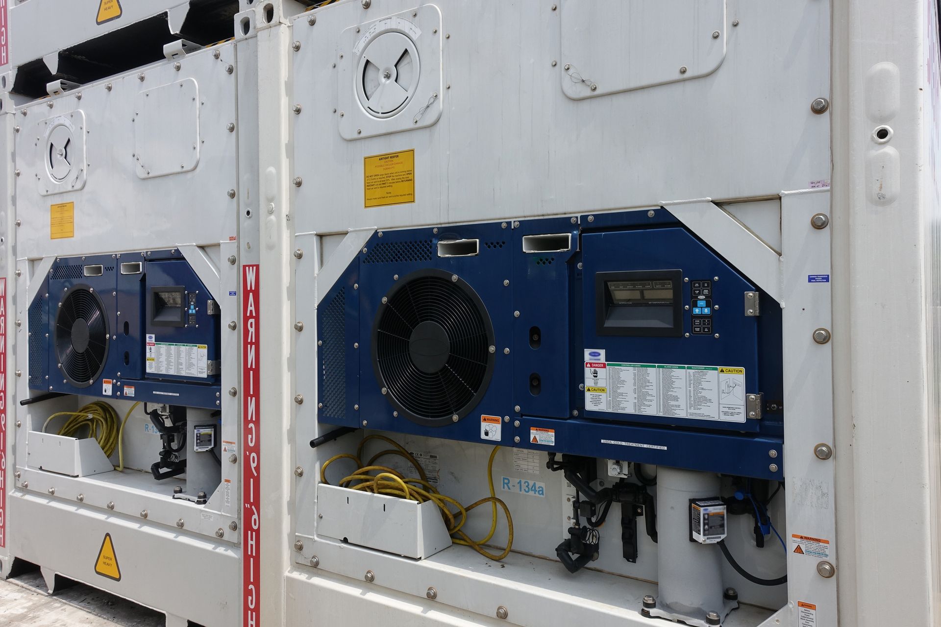 Two refrigerated containers are parked next to each other.