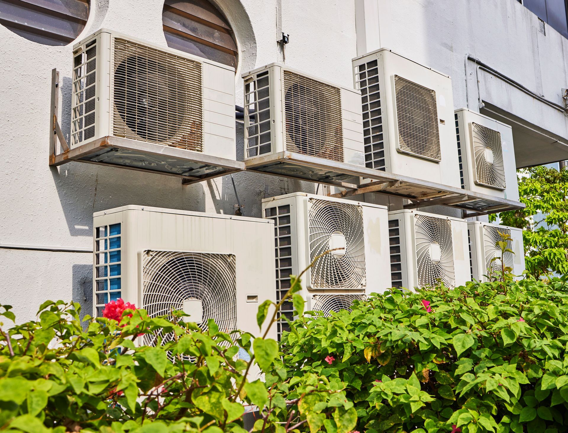 A row of air conditioners on the side of a building
