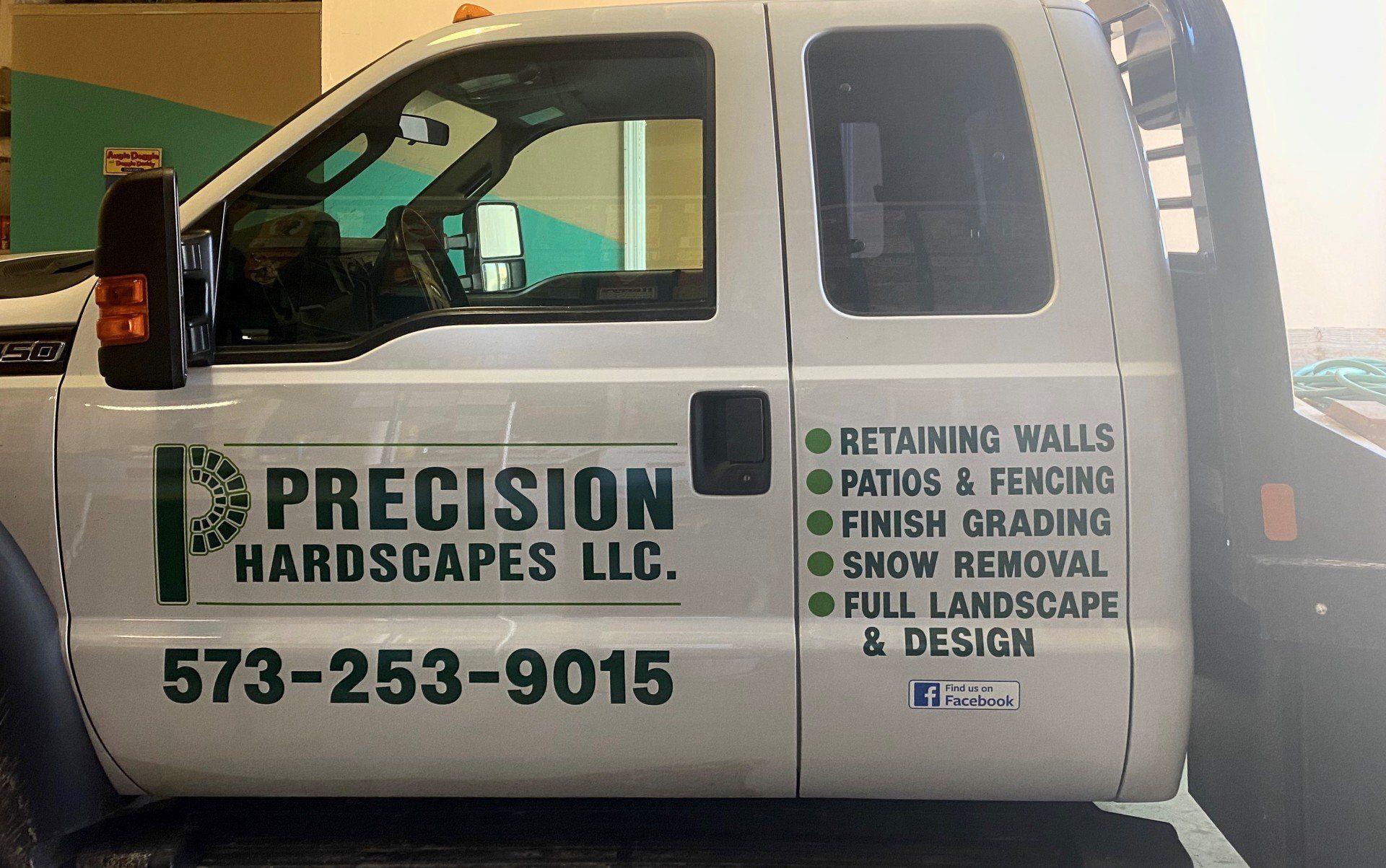 A white truck with precision hardscapes llc written on the side