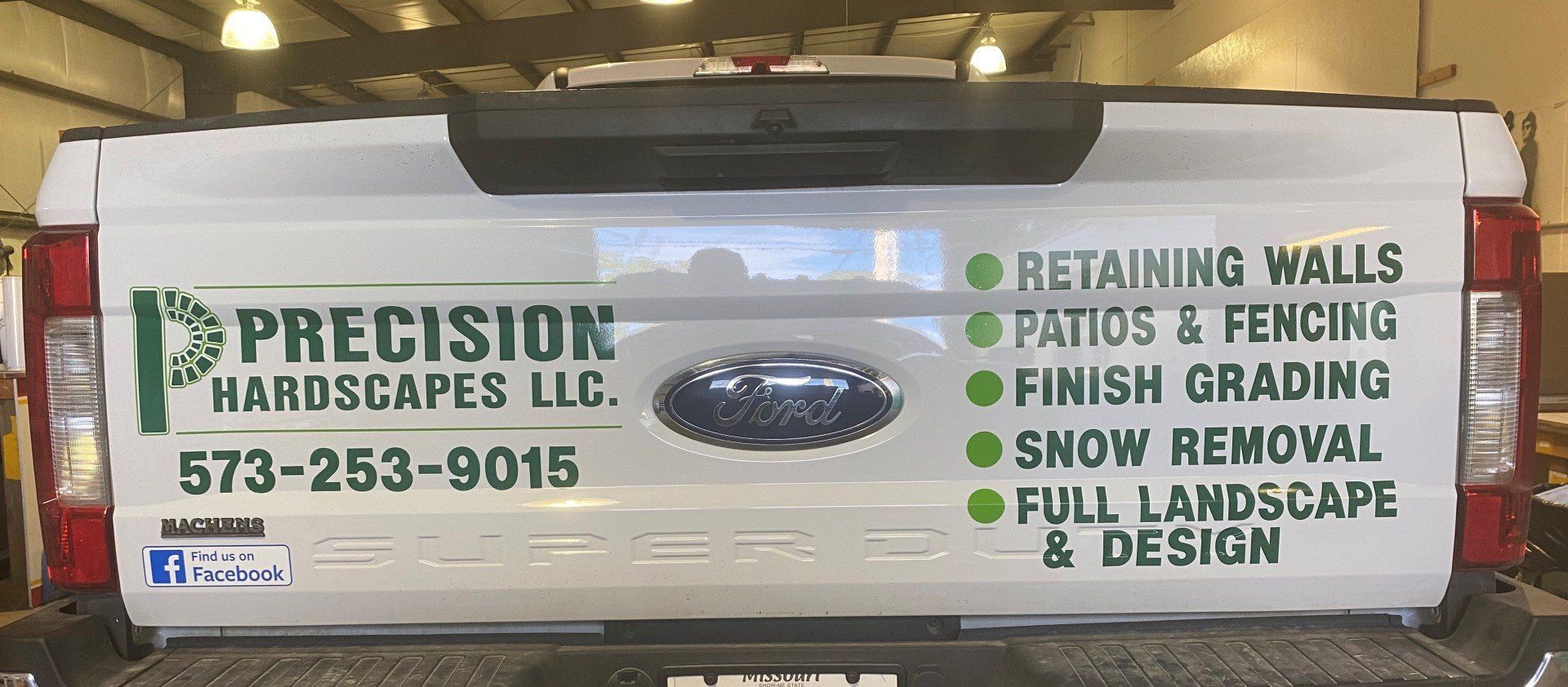 A white truck with precision hardscapes llc written on the back