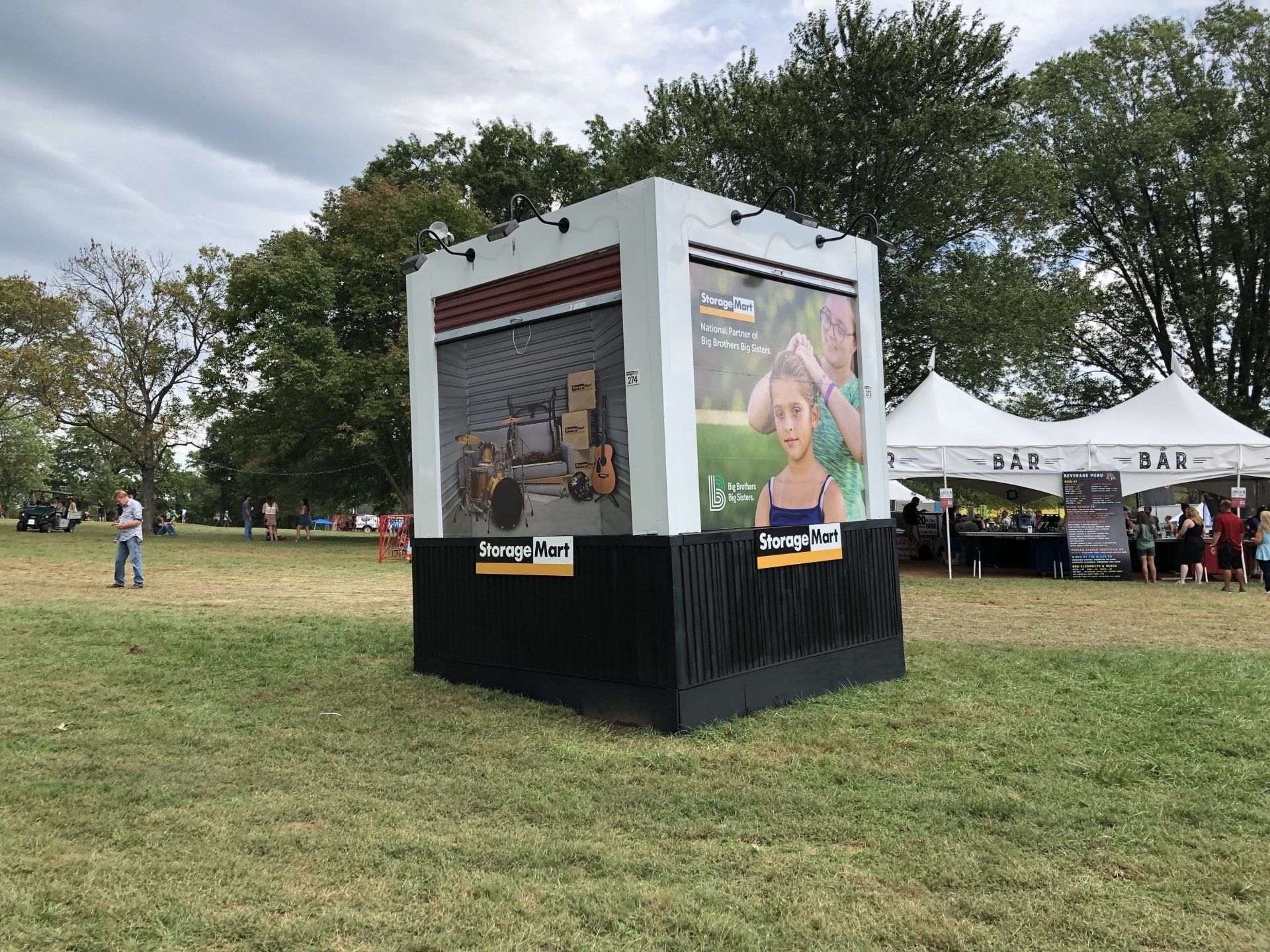 A large billboard is sitting in the middle of a grassy field.